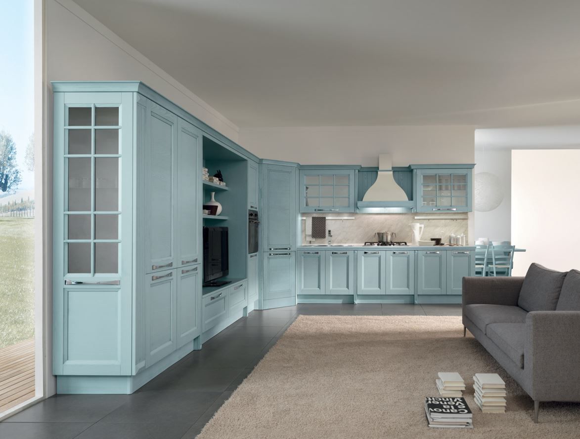 Cucina e soggiorno di colore azzurro, con mobili, divano e tappeto.