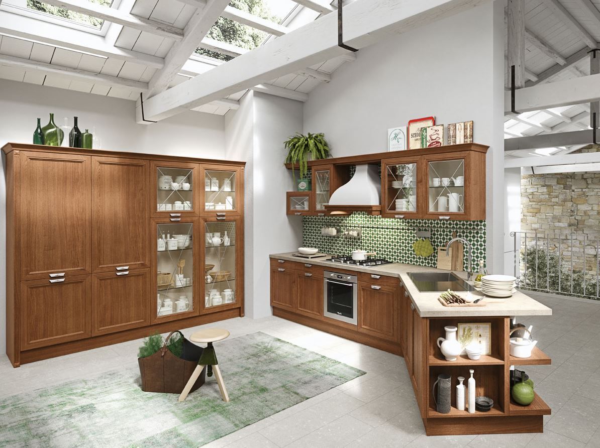 Cucina in legno con mobili, isola e paraschizzi piastrellato sotto una cappa bianca.