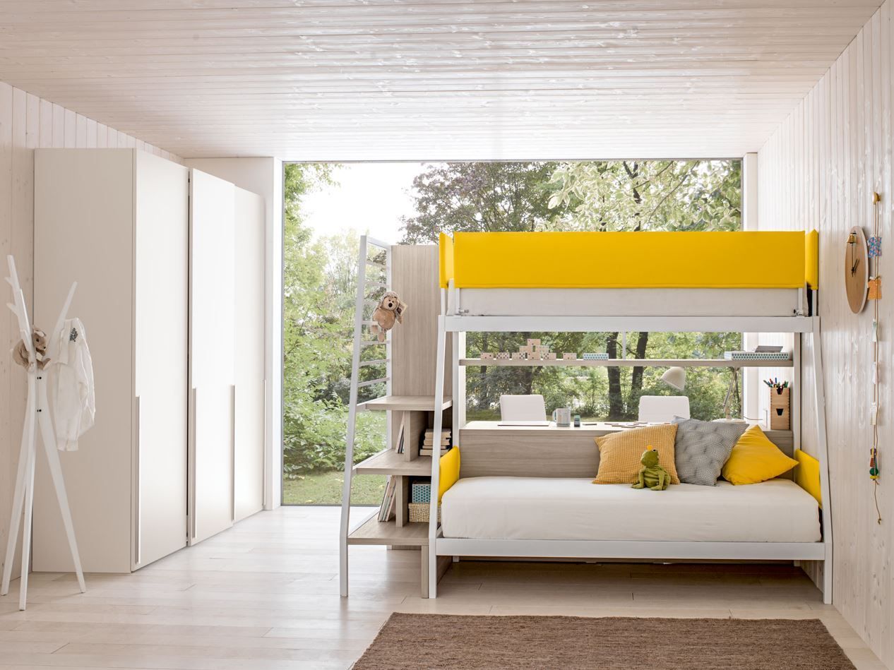 Una camera da letto moderna con letto a castello giallo e grigio, scrivania e armadio bianco. Un'ampia finestra si affaccia sul giardino.