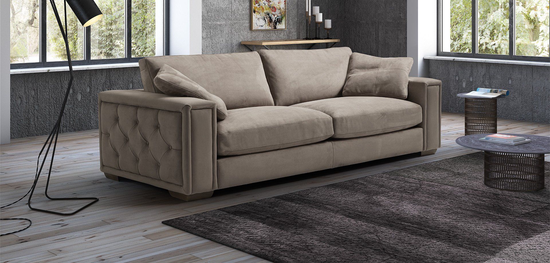 Divano beige in un soggiorno moderno con tappeto e finestre.