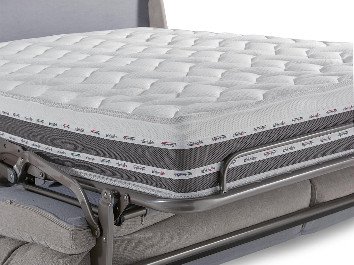 Un divano letto pieghevole con materasso trapuntato bianco e grigio.