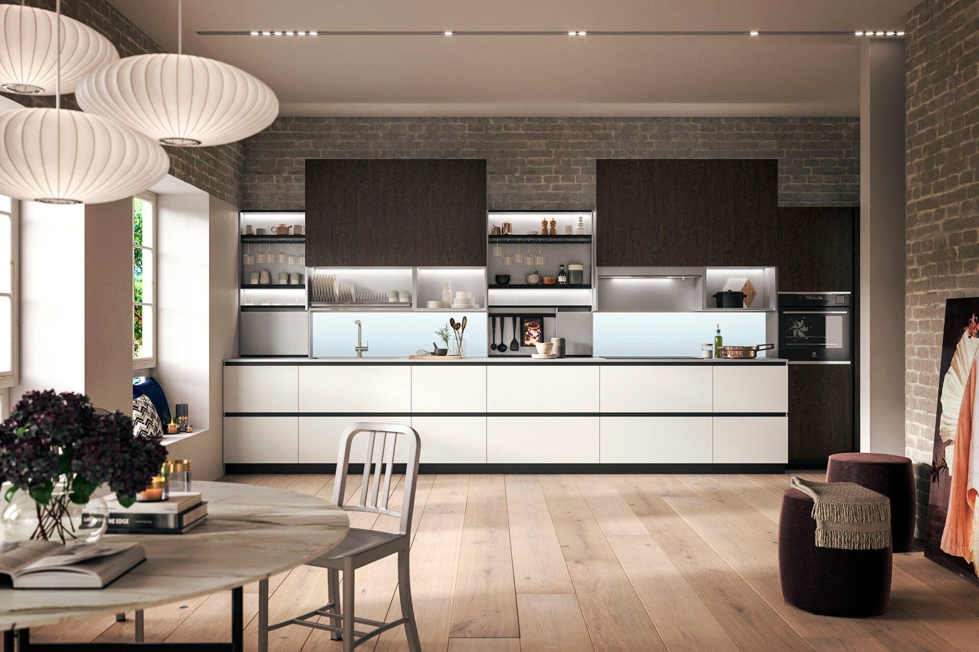 Cucina moderna Snaidero con mobili bianchi e scuri, pavimento in legno chiaro e grandi lampade a sospensione.
