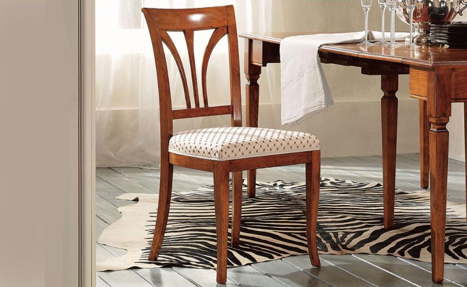 Sedia in legno con seduta decorata, vicino a un tavolo da pranzo su un tappeto zebrato.