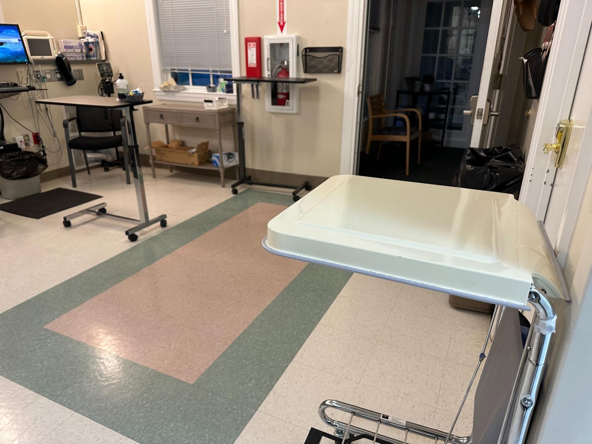 A hospital room with a tray on the floor
