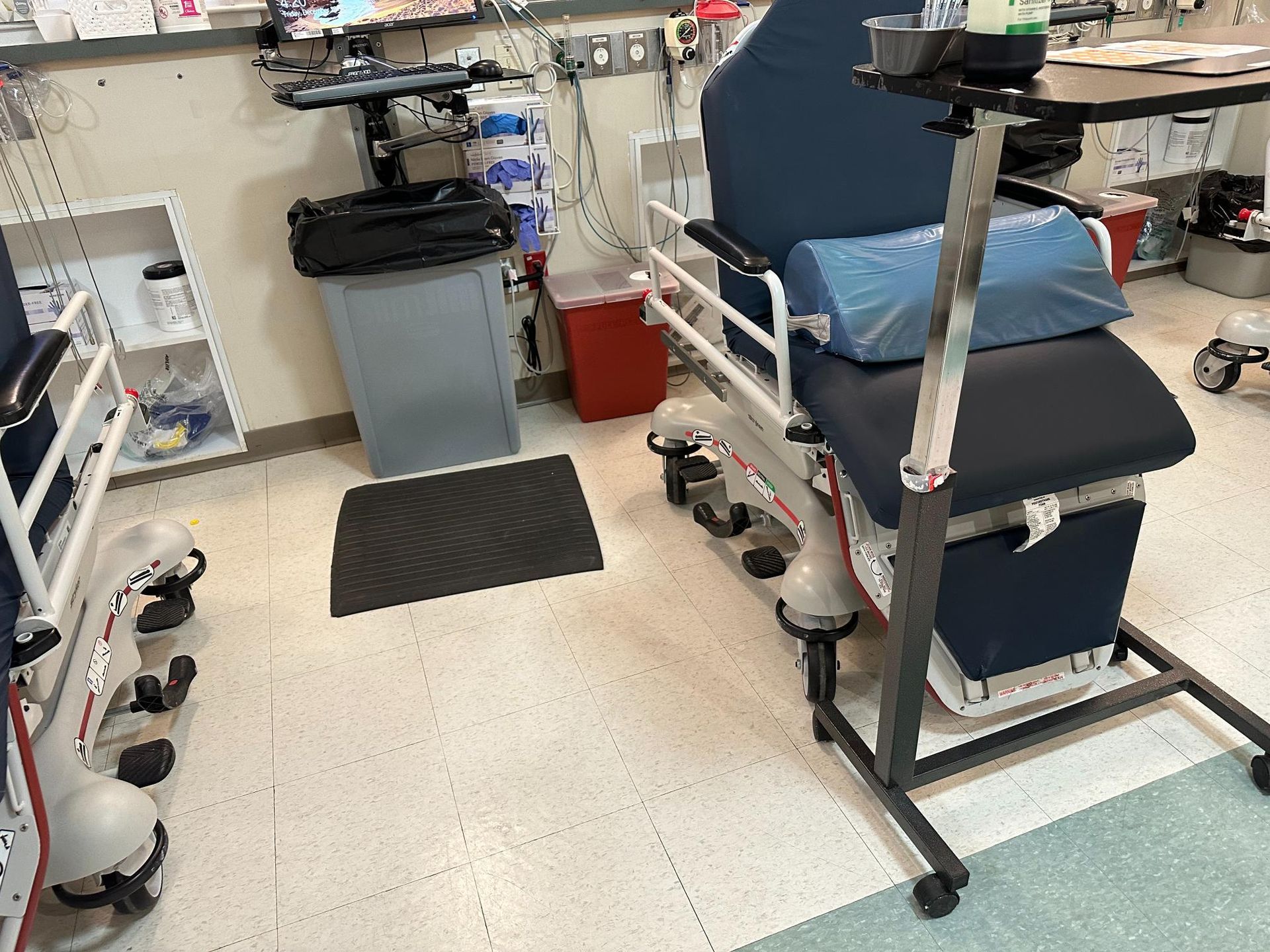A hospital room with a chair and a table.