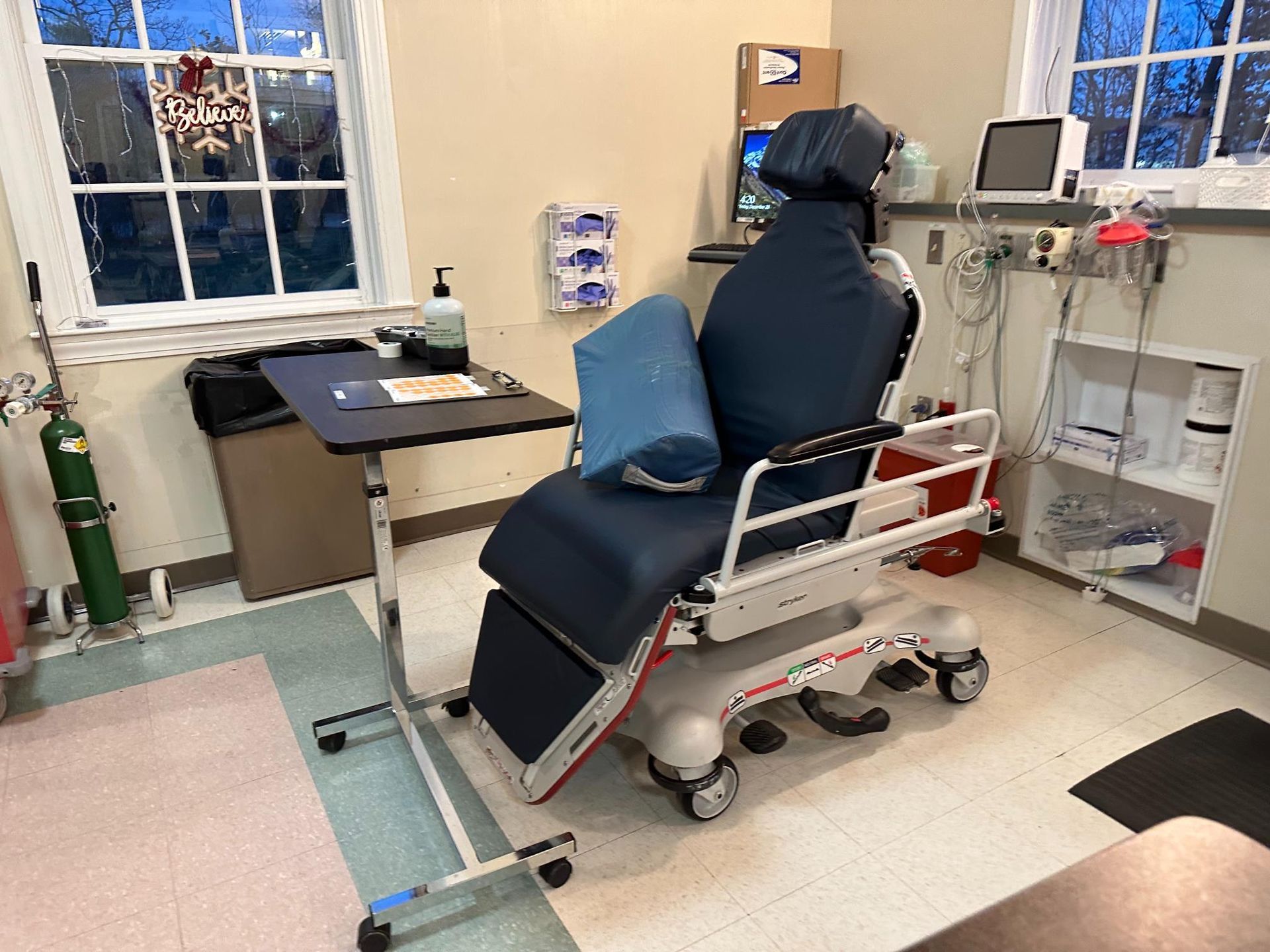 A hospital room with a chair and a table.