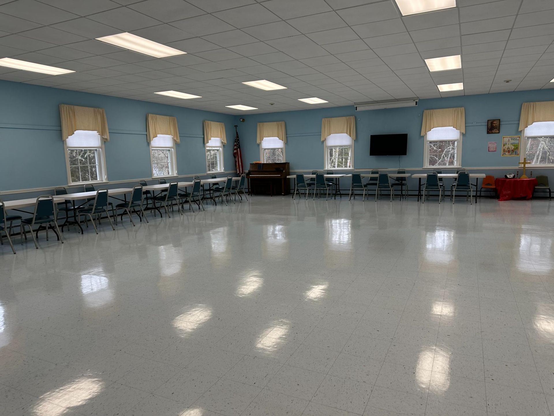A large empty room with tables and chairs in it.