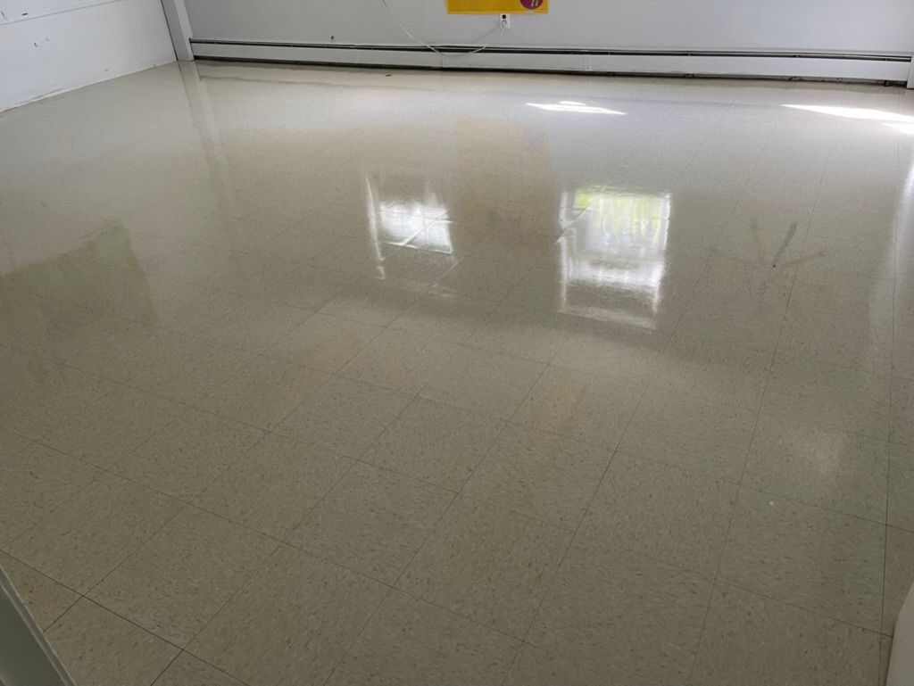 A shiny floor in a room with a yellow sign on the wall.