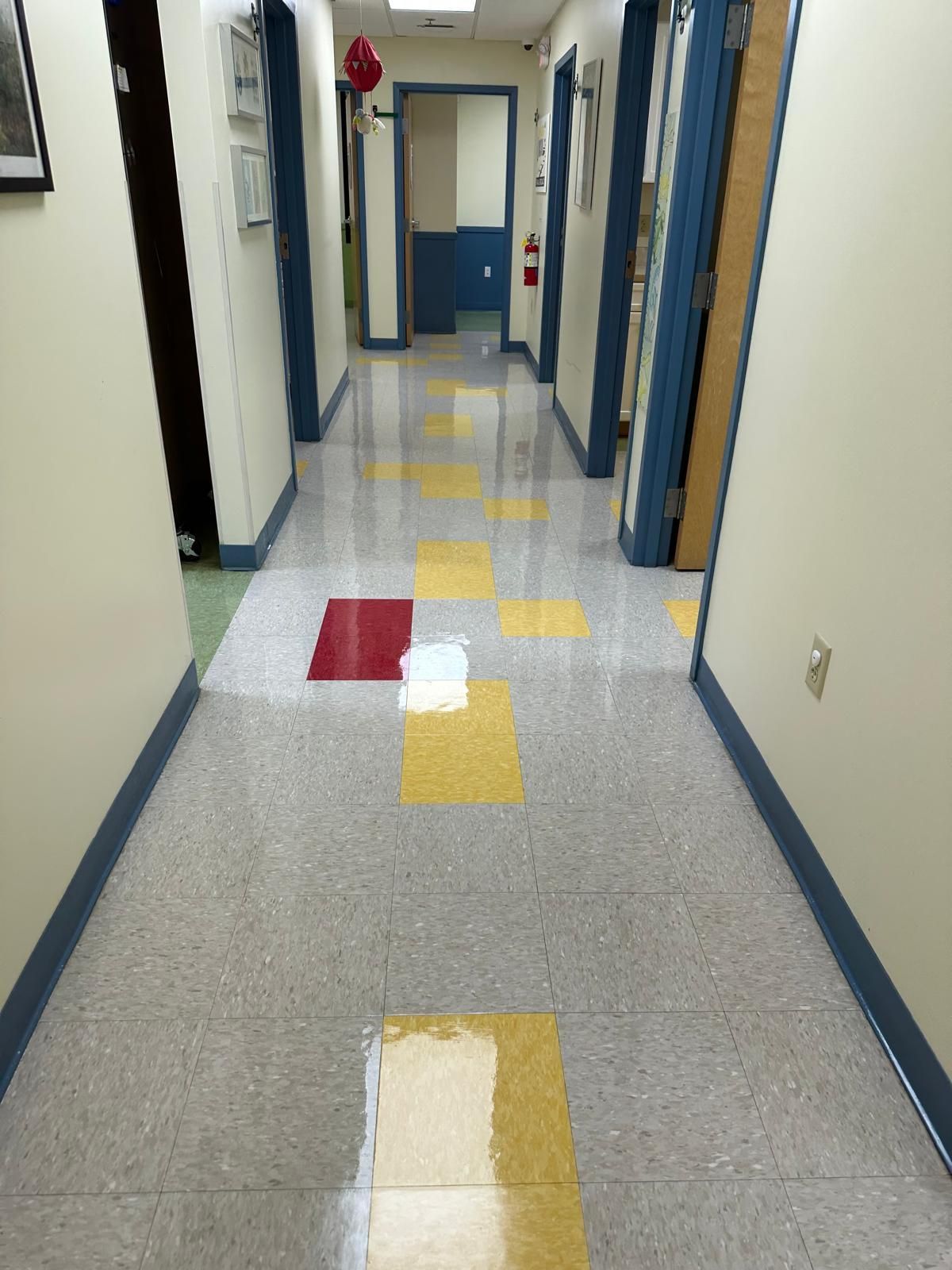 A hallway with a red and yellow tile floor