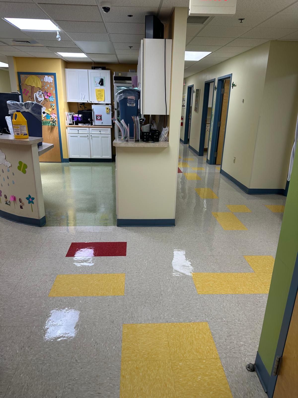 A very long hallway with yellow and red tiles on the floor