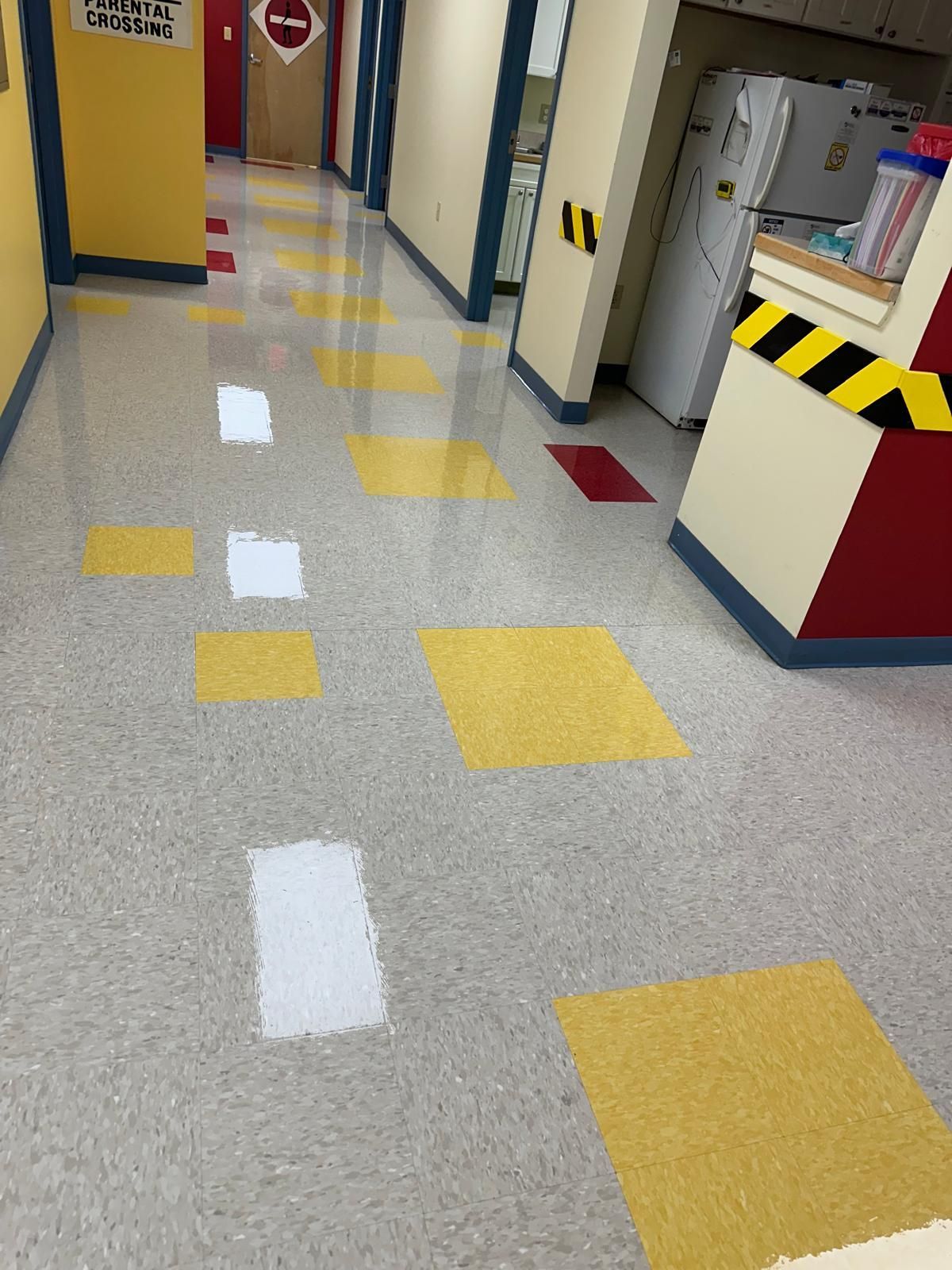 A hallway in a building with yellow and white tiles
