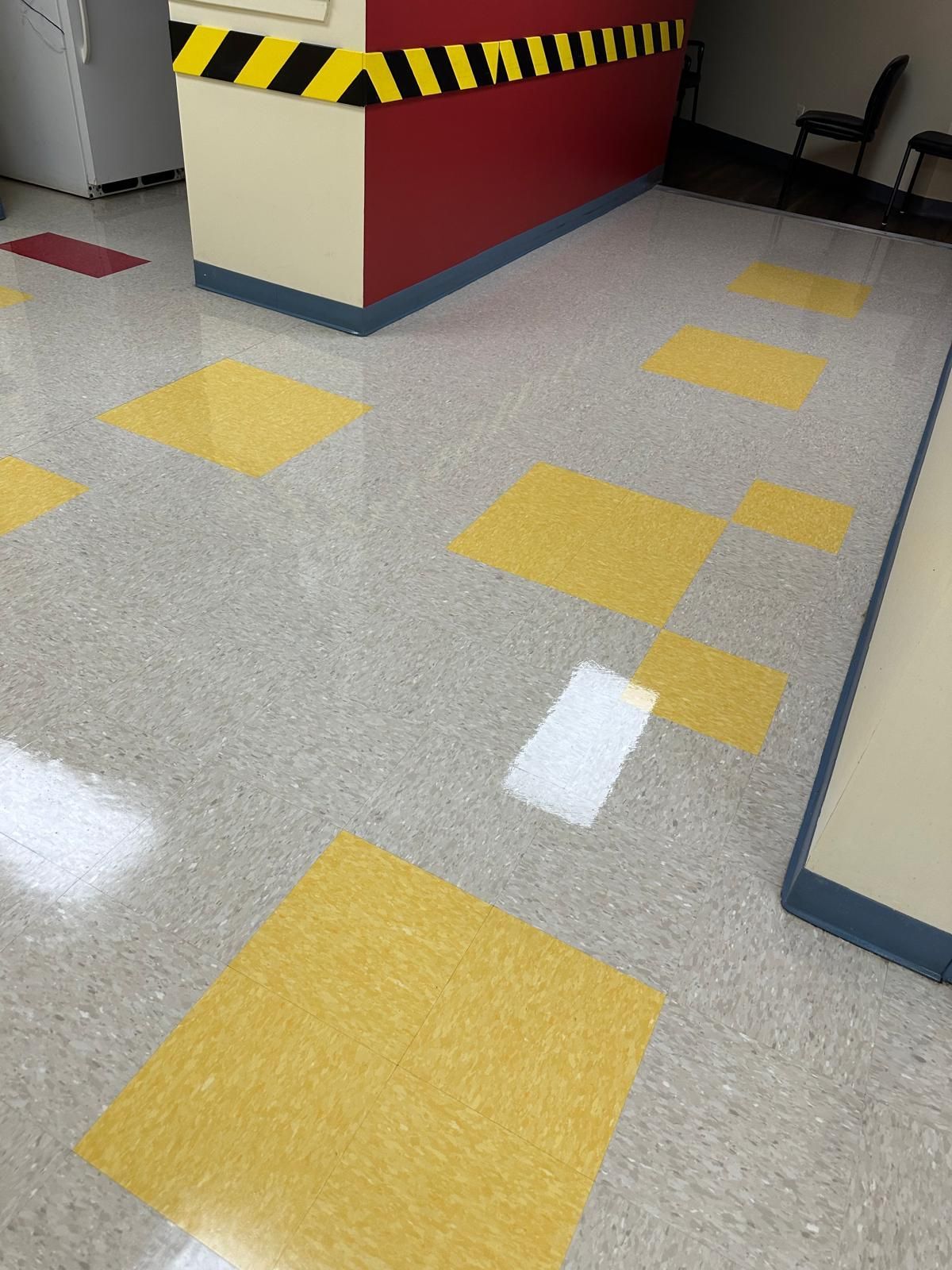 A hallway with yellow and white tiles on the floor