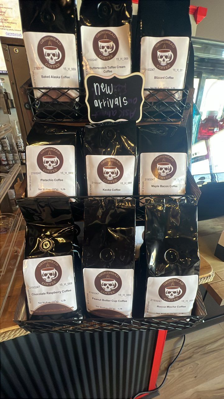 A wire display rack holds multiple bags of coffee with circular skull logos, organized in three rows of three.