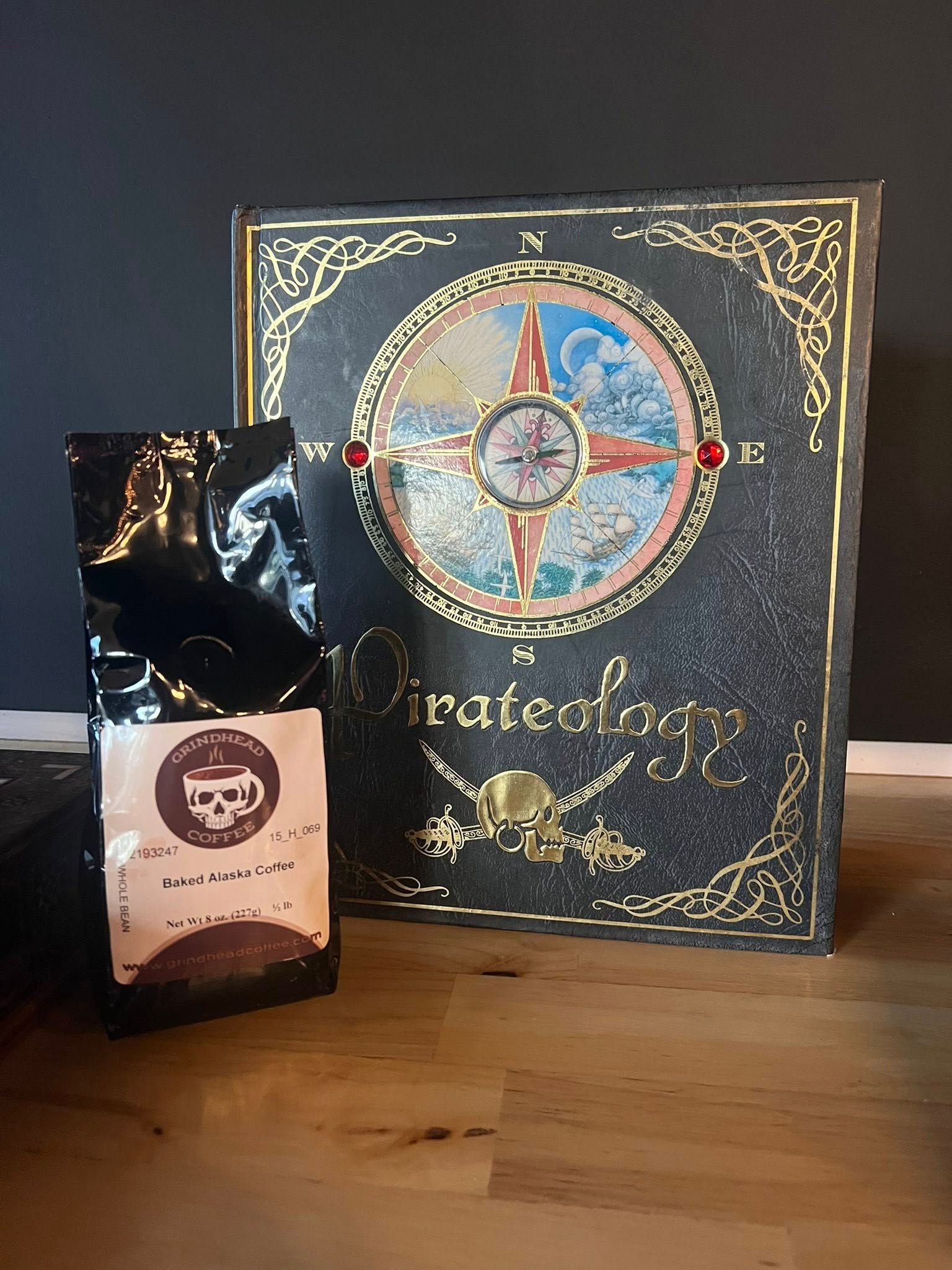 A bag of dark-roasted coffee next to a copy of the book 