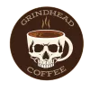 A brown circular logo featuring a skull-shaped coffee mug with steam rising above it, reading "GRINDHEAD COFFEE."
