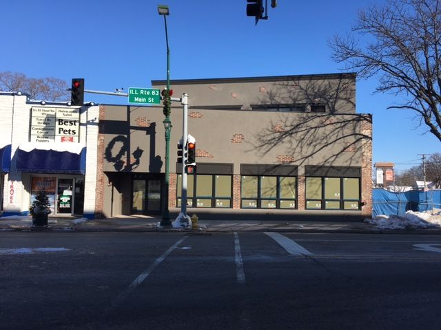 Building on a street corner with boarded-up windows and