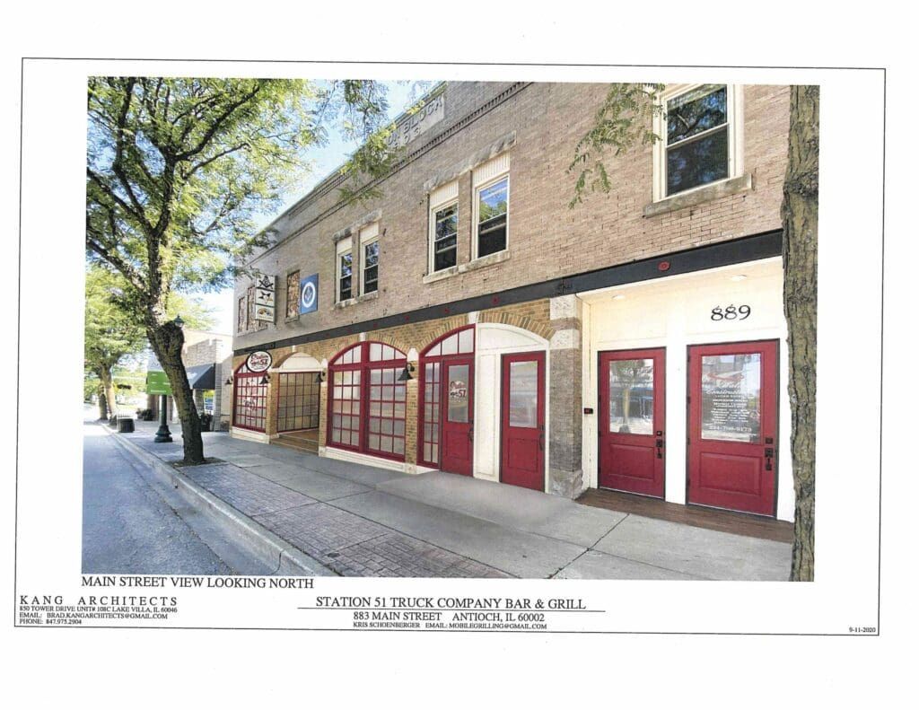 Building exterior with arched doorways, red doors, and windows on a brick facade.