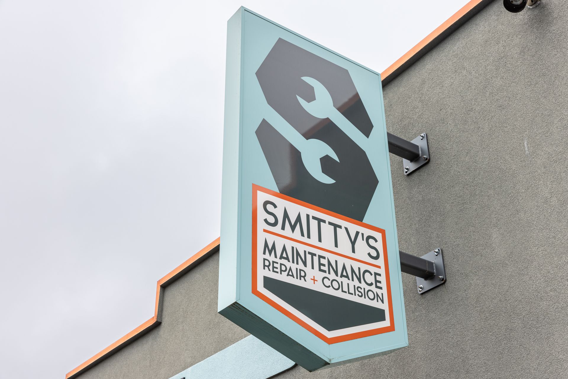 Sign for Smitty's Maintenance with logo of a wrench inside of an