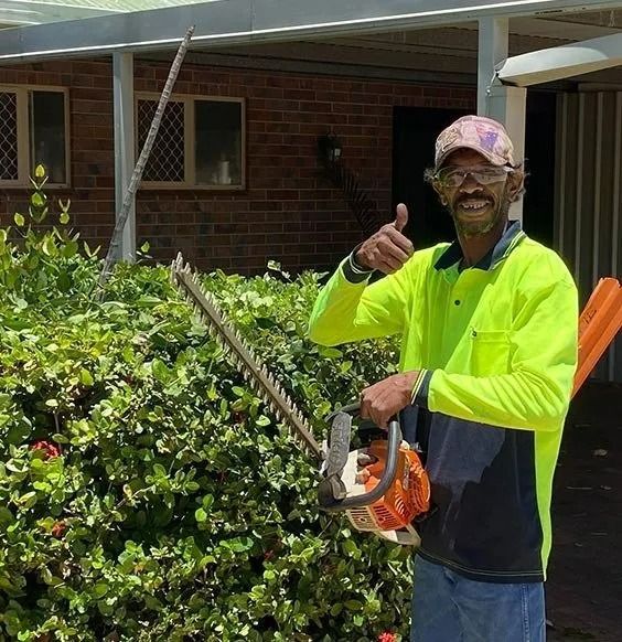 Man With Hedge Trimmer Gives Thumbs Up — Darrell's Mowing Services in Sunset, QLD