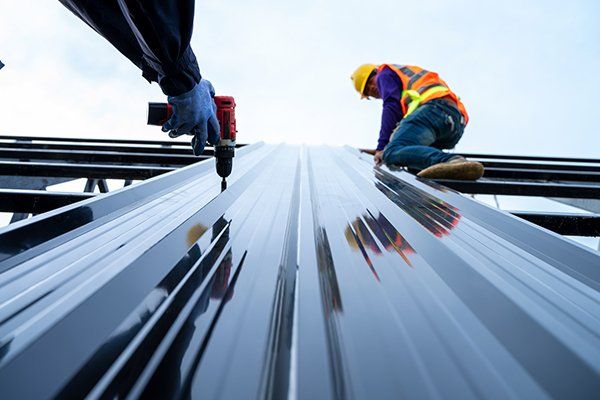 Roofer Installing New Roof Using Pneumatic Nail Gun — Etowah, NC — John Balken Jr. Roofing Company Roofer Installing New Roof Using Pneumatic Nail Gun — Etowah, NC — John Balken Jr. Roofing Company