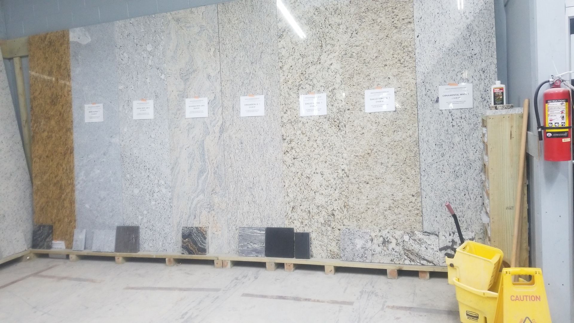 Workbench with sample boards, notes, tools, and a yellow caution sign in a workshop area