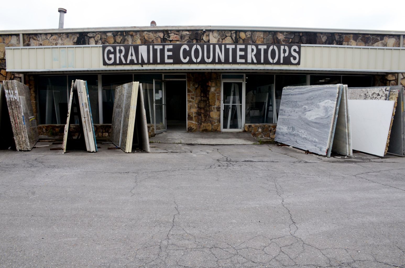 Granite countertop storefront with stone slabs and samples displayed outside