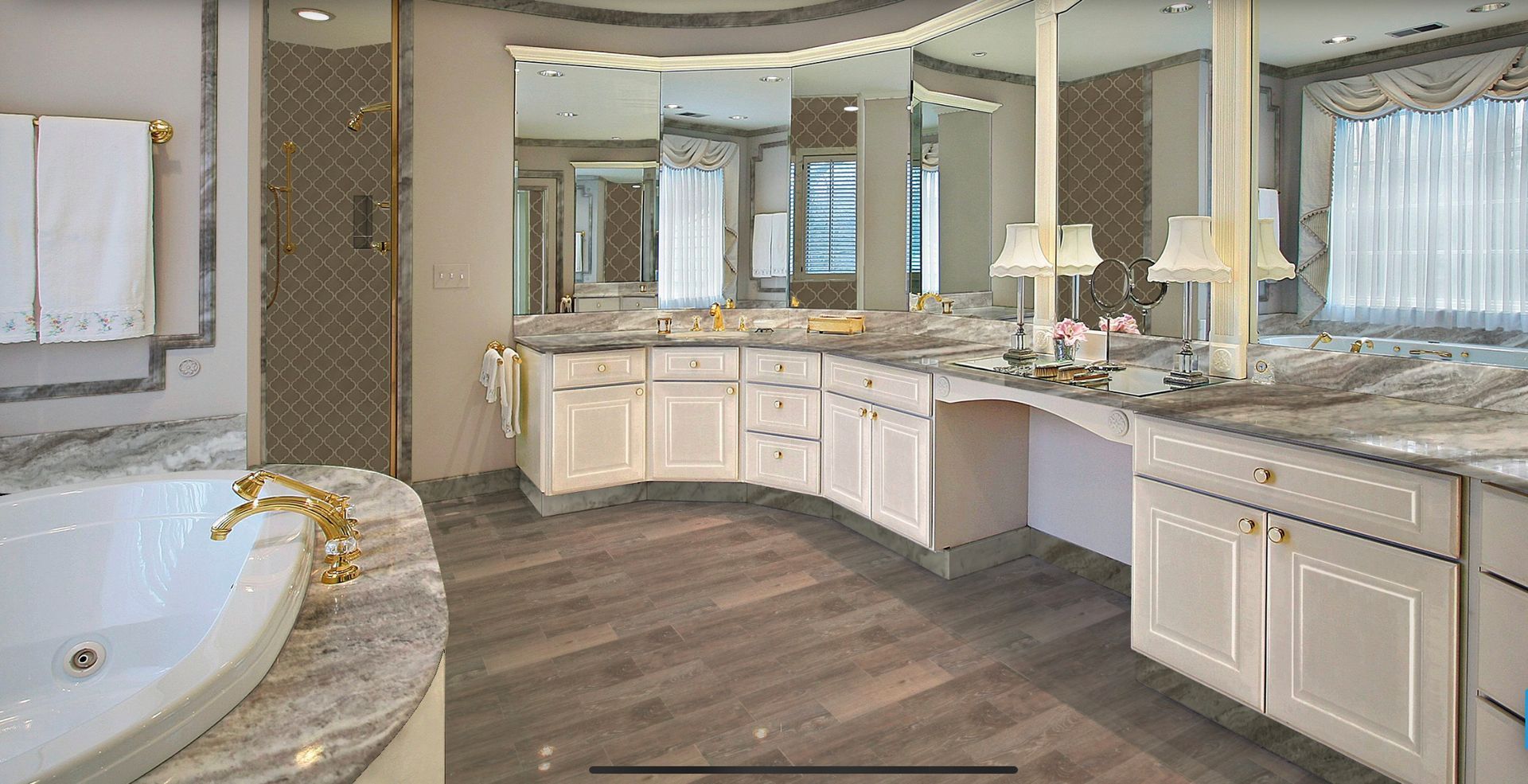 Bright modern bathroom with double vanity, large mirrors, white cabinets, and a corner soaking tub