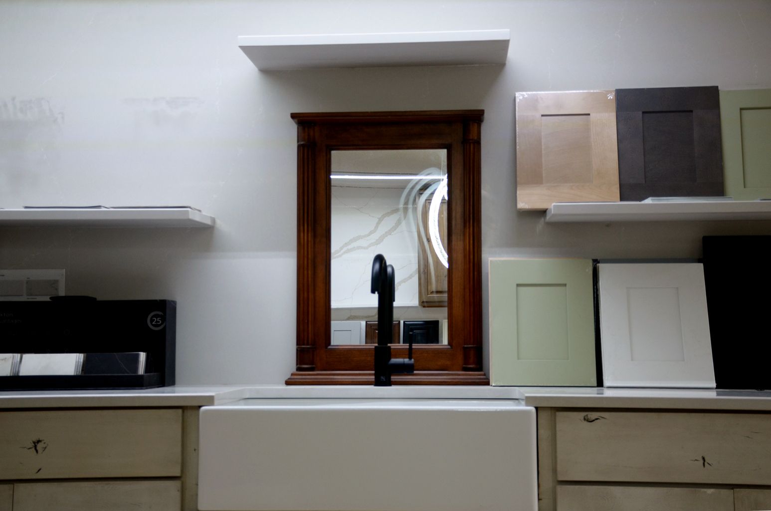 Modern kitchen with white cabinets, wooden window, and sink centered beneath a small shelf.
