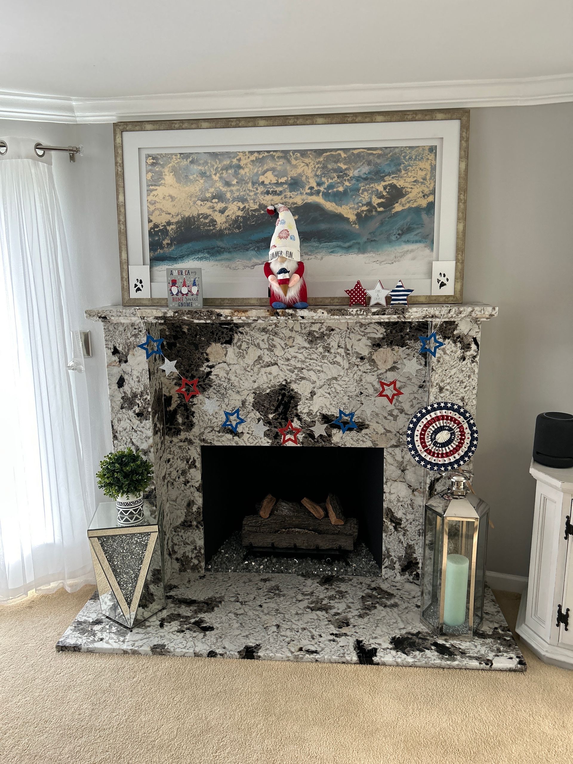 Living room fireplace with a snowy holiday mantle, framed painting above, and decor on both sides