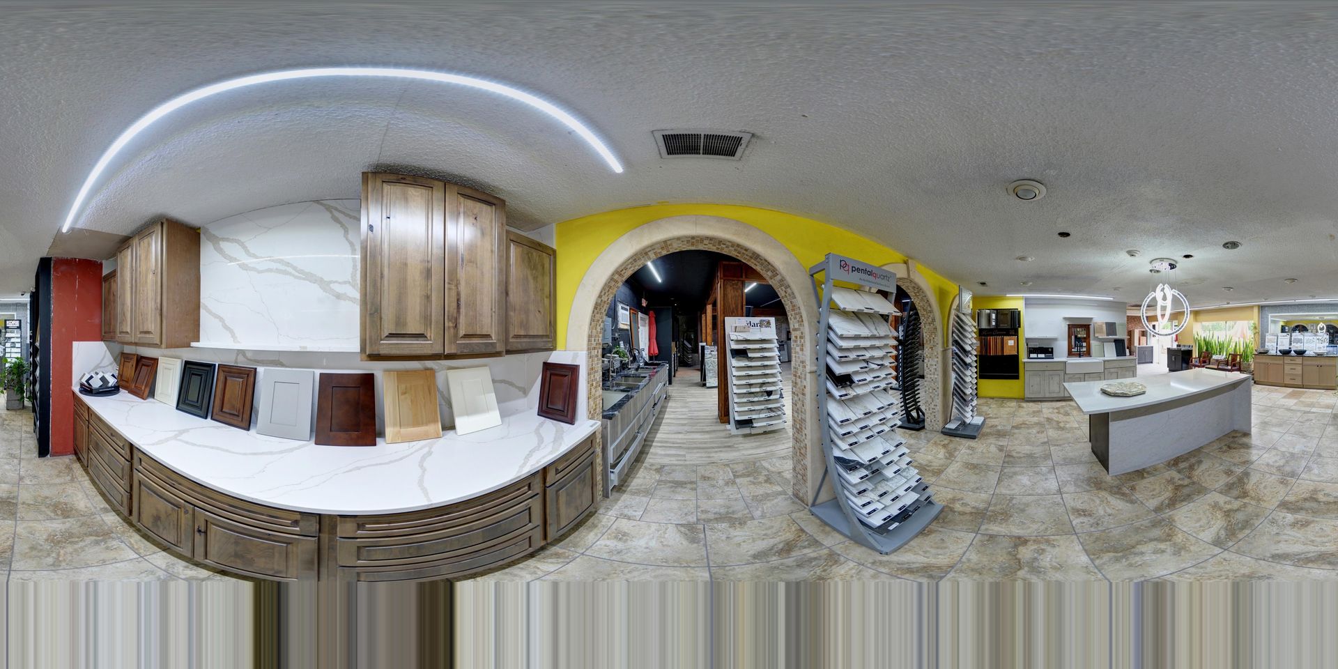 Panoramic view of a bright indoor café or mall with arches, counters, and hanging décor