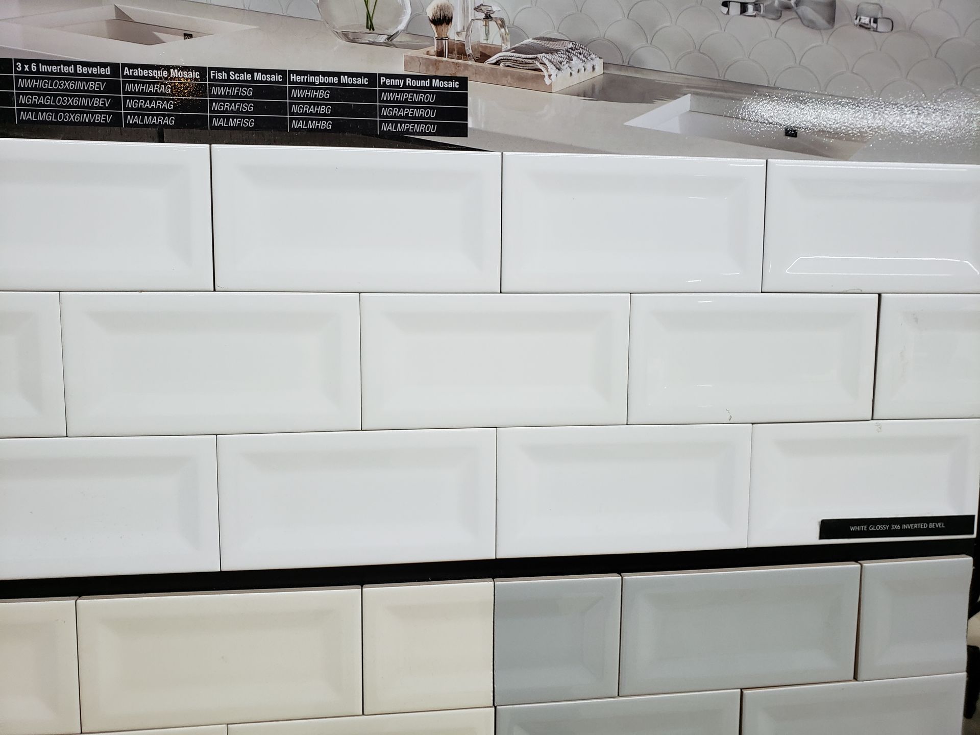 Stacked white rectangular tiles or bricks displayed in rows against a light wall.