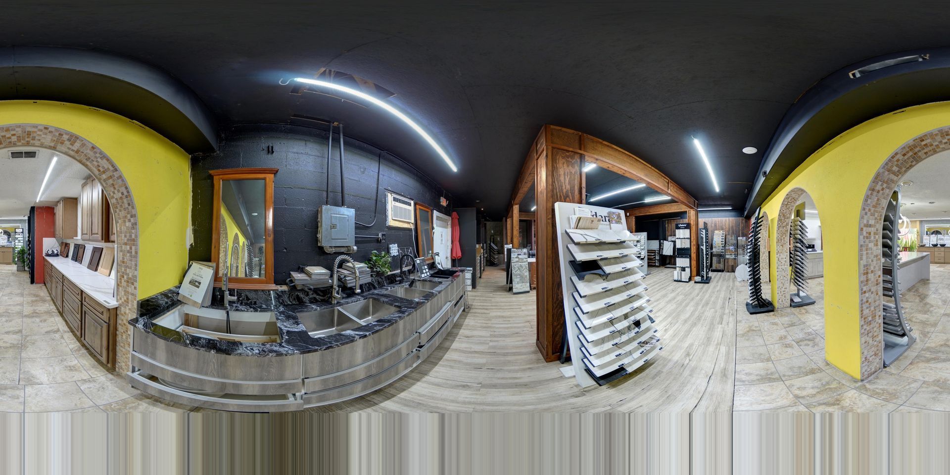 Panoramic view of a modern indoor store with glass counters, white shelves, and yellow walls