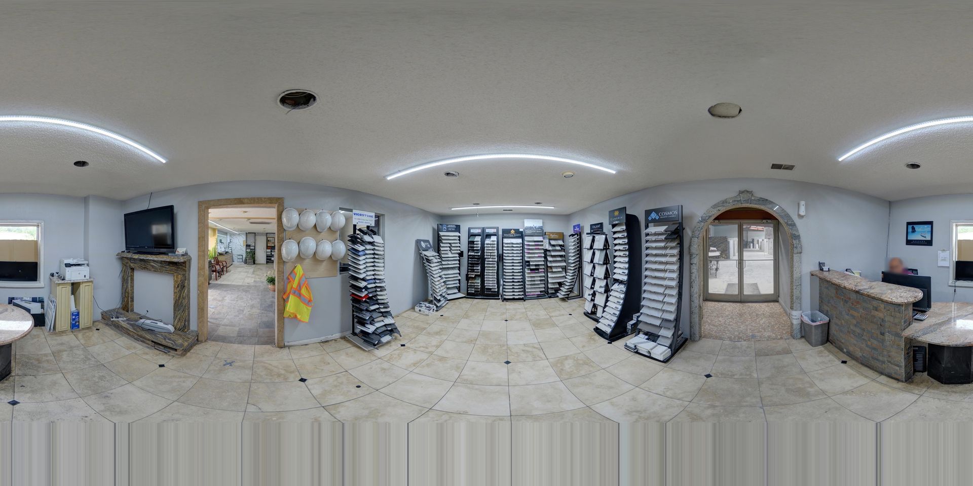 Wide pharmacy interior with shelves of products, bright lights, tiled floor, and a service counter