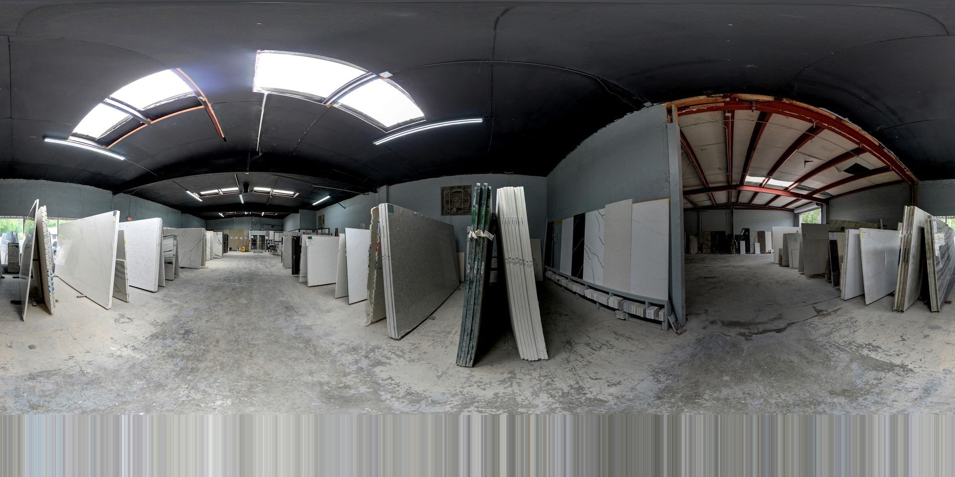 Panoramic view of an unfinished warehouse interior with white partition walls and exposed ceiling beams