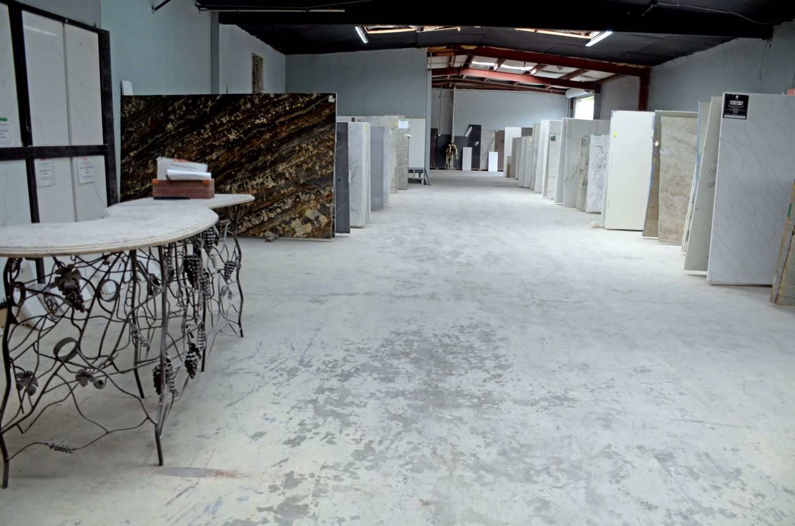 Empty industrial room with white floors, columns, and counters in a warehouse-like space