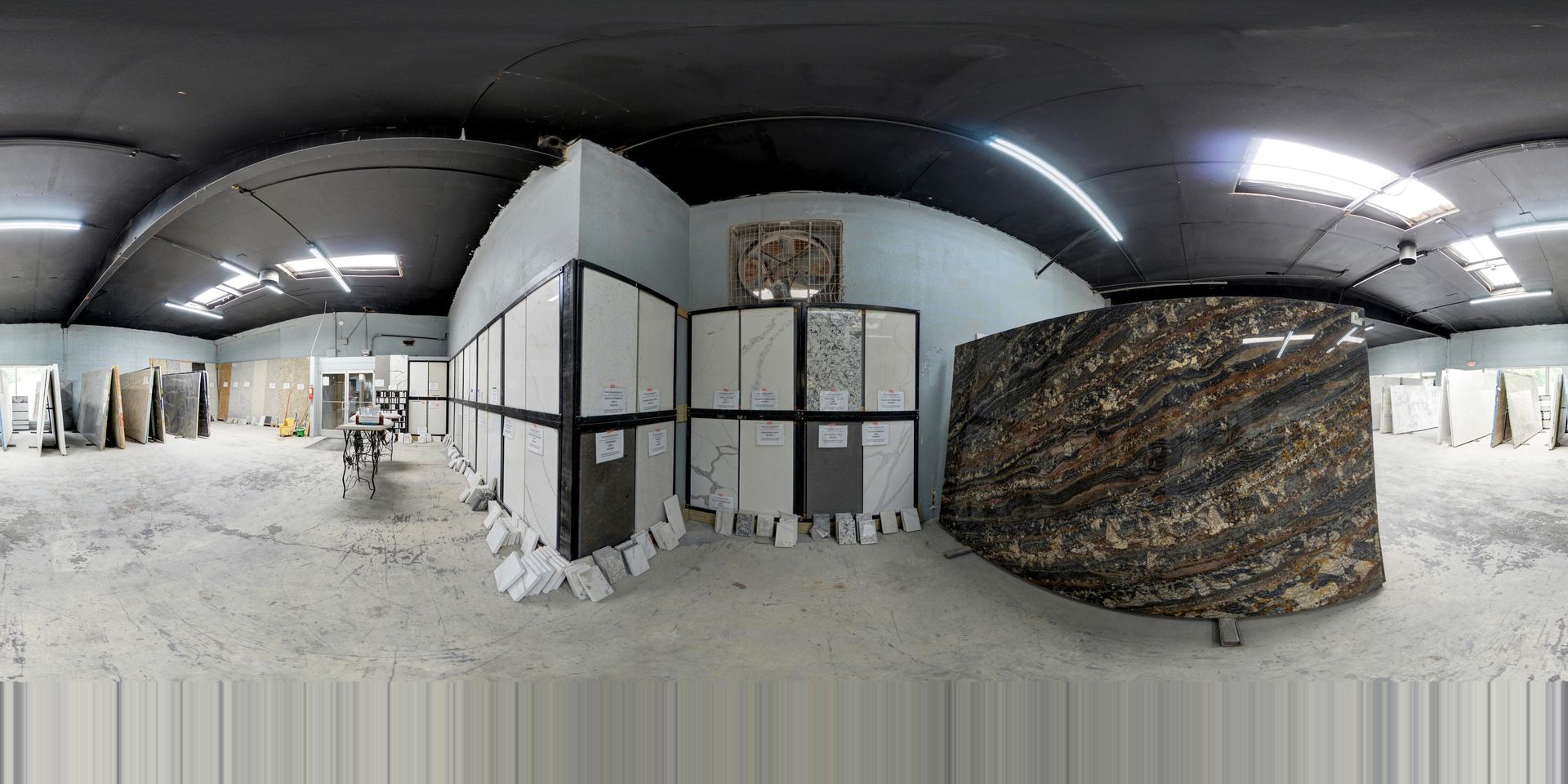Wide-angle view of a snow-covered indoor space with a central partition, arched ceiling, and bright lights