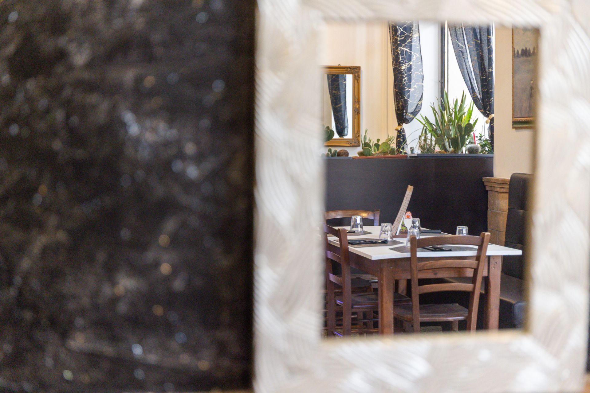Tavoli da pranzo vuoti visti attraverso una piccola finestra