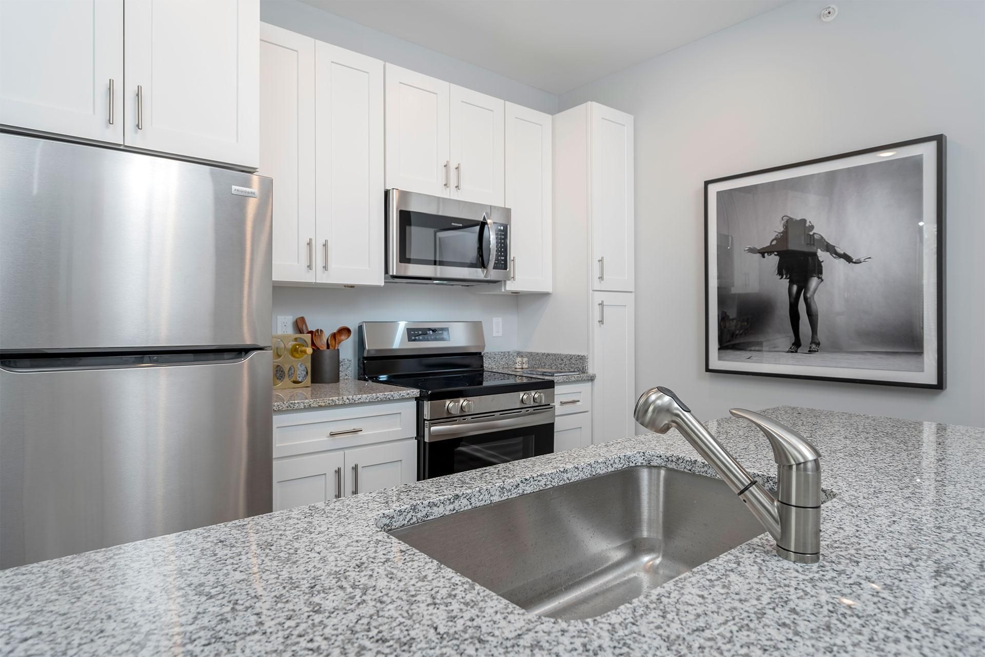 A modern kitchen with granite countertops and stainless steel appliances.