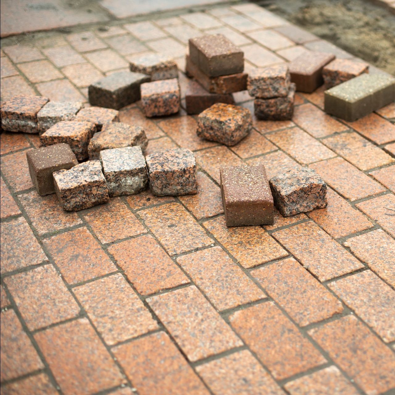 A pile of bricks sitting on top of a brick walkway.