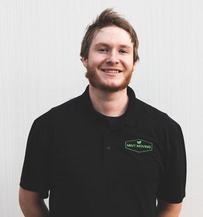 Man with reddish-blonde hair and a beard, wearing a black polo shirt with