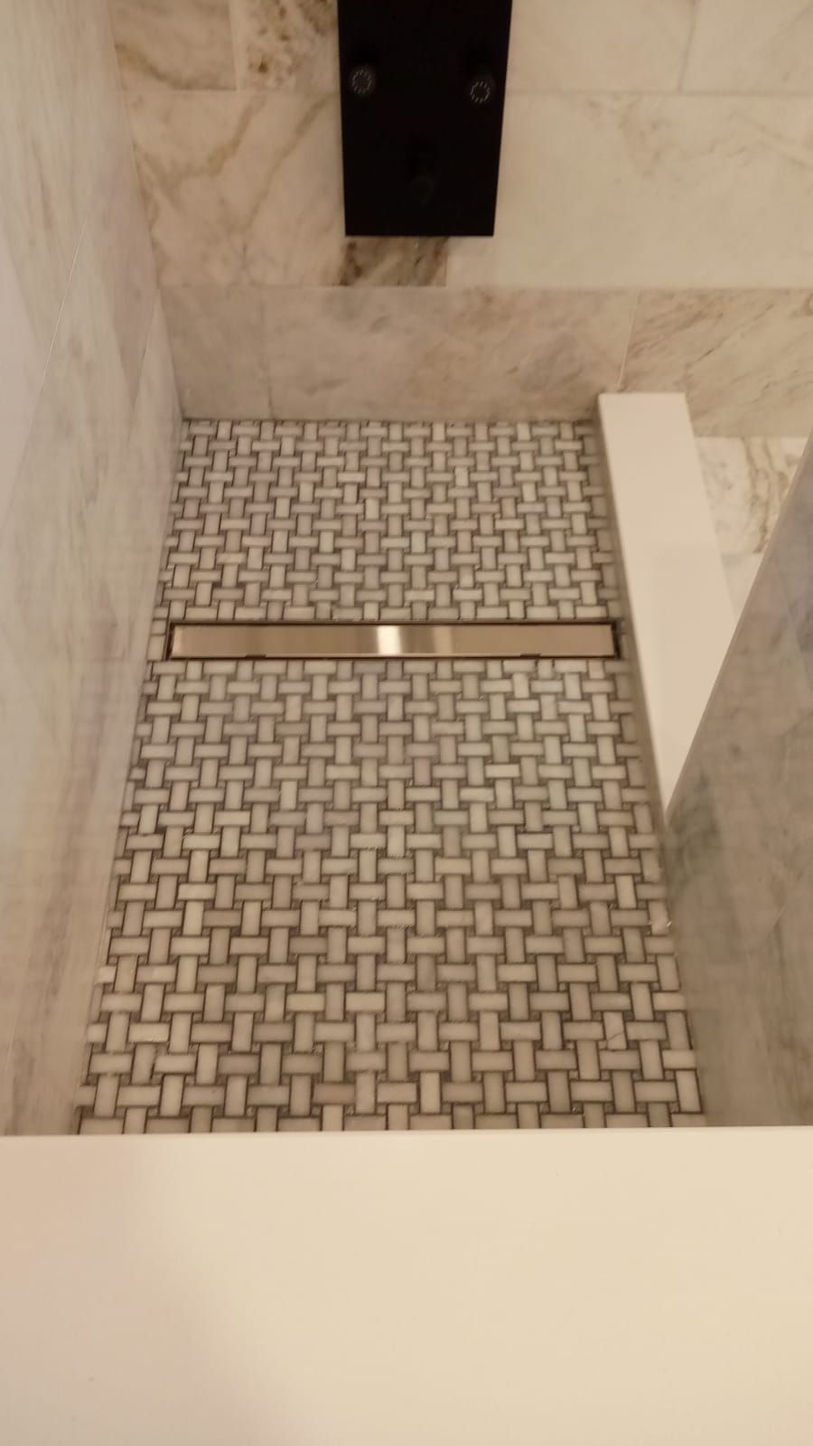 Accessible shower with fold-down bench and built-in grab bars in a tiled bathroom