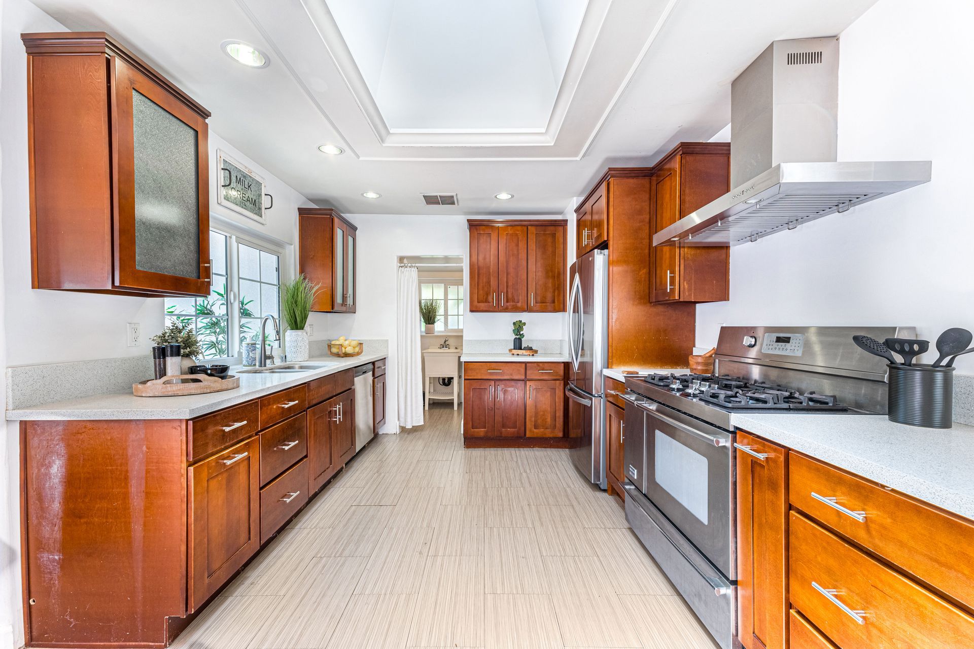 Bright kitchen with wood cabinets, stainless appliances, and a central island in a clean white interior