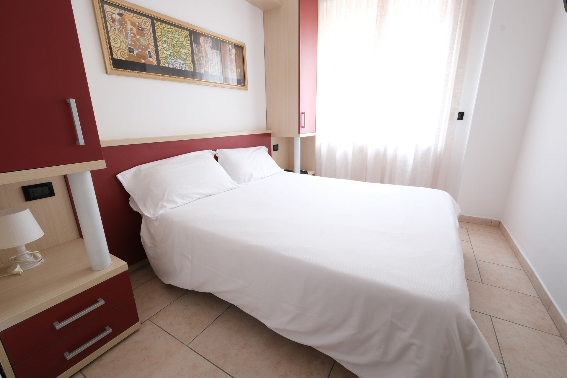 A bedroom with a large bed and a nightstand