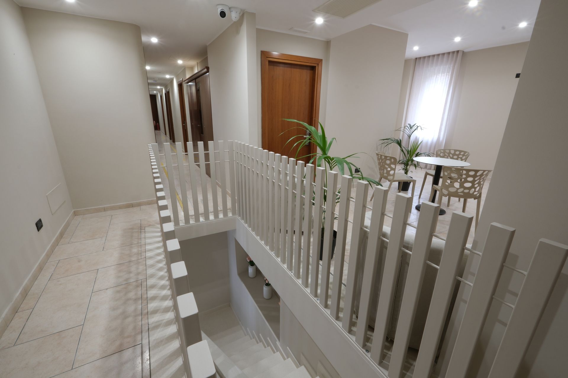 A hallway with stairs leading up to the second floor of a building.