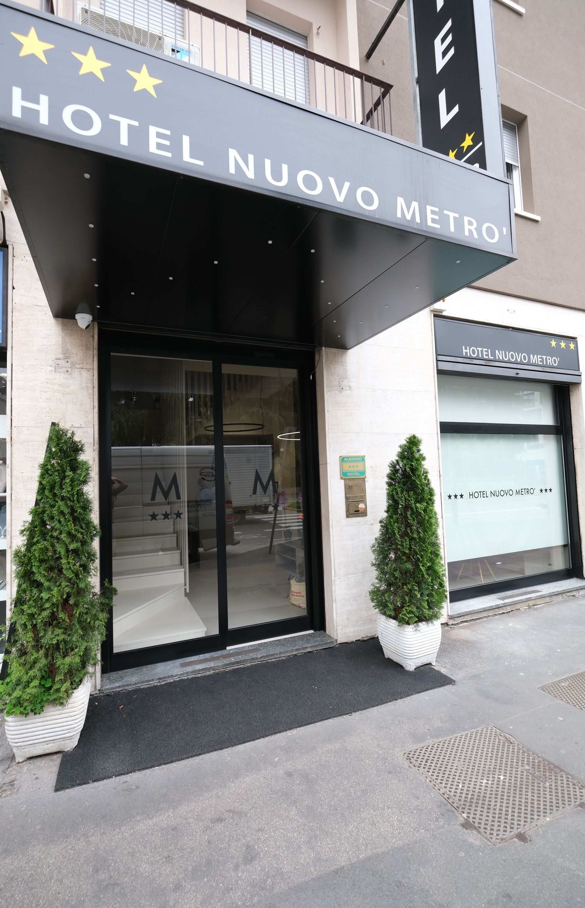 The entrance to the hotel nuovo metro has a sliding glass door