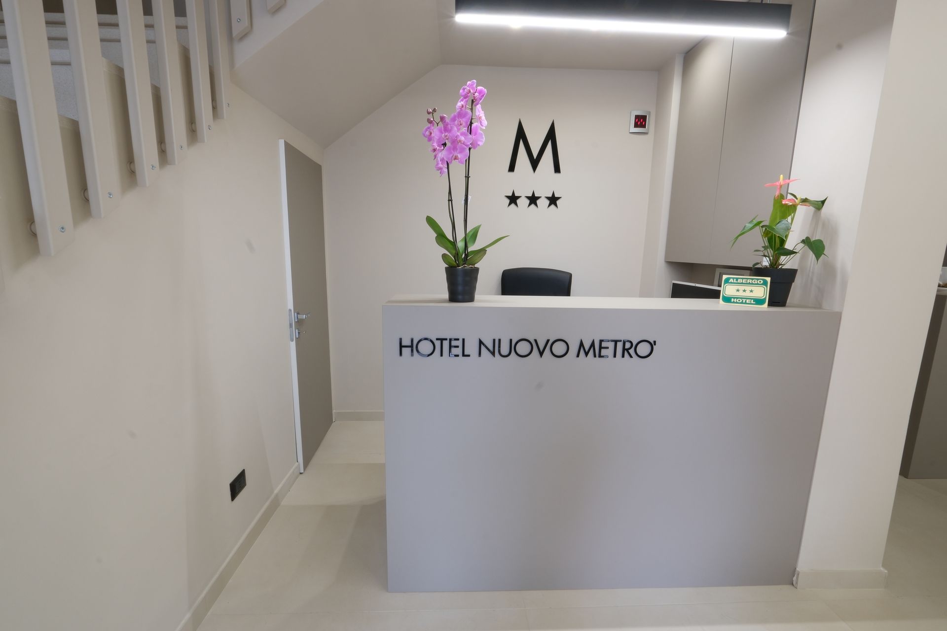A hotel reception desk with a purple flower on it