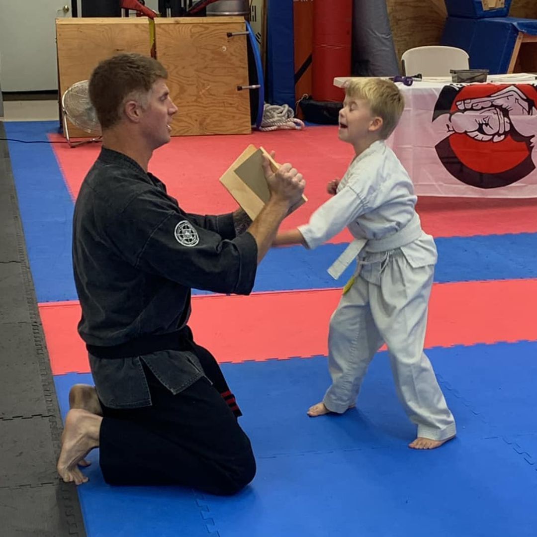 A boy and a girl are practicing taekwondo together.