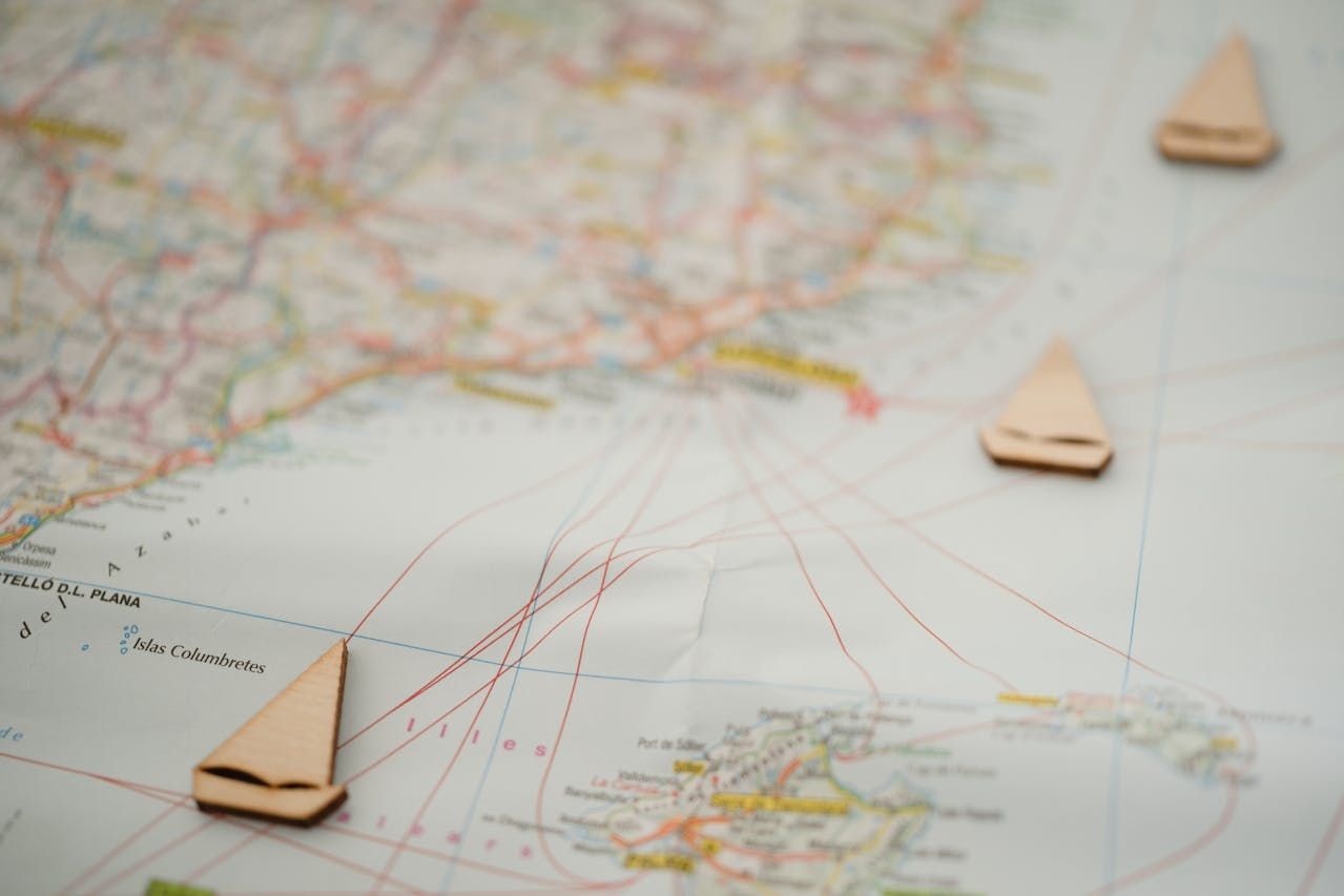 Three wooden sailboats are sitting on top of a map.