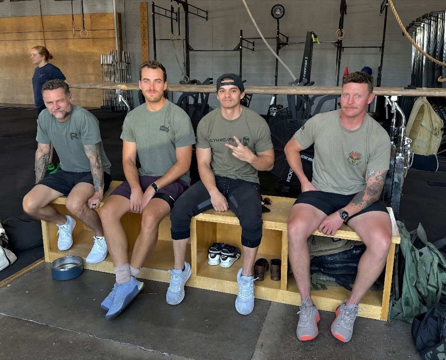 A group of men are sitting on a bench in a gym.