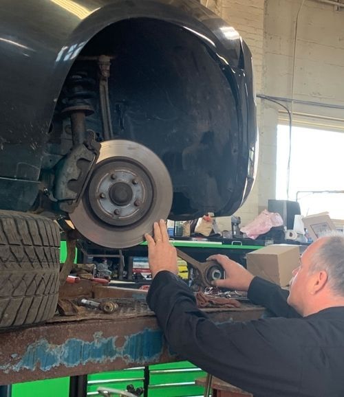 A man is working on a car in a garage